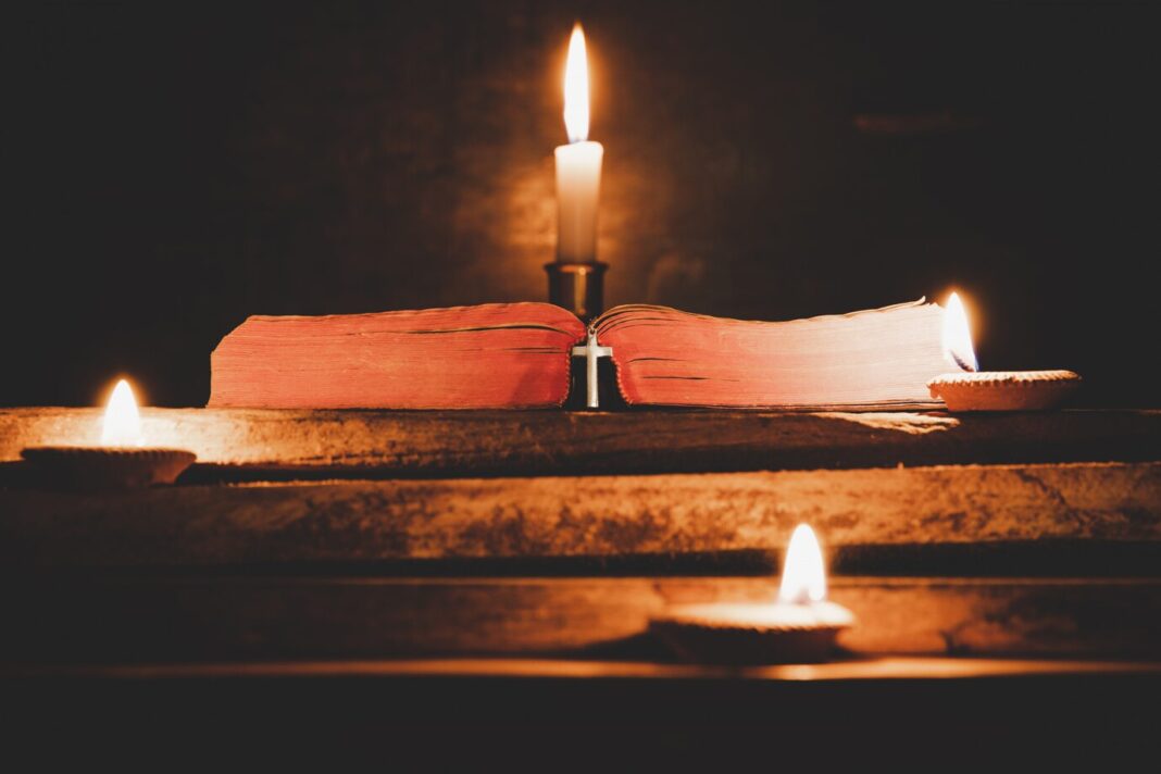 open-holy-bible-candle-old-oak-wooden-table_1150-9236