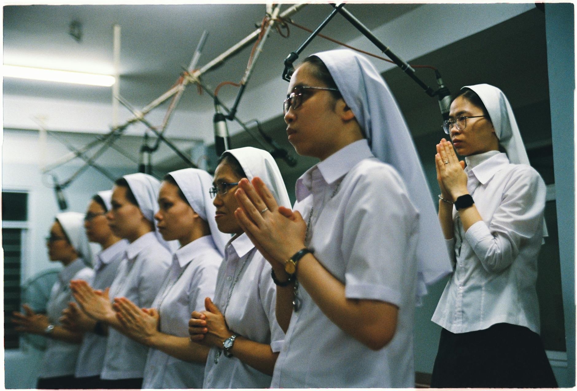 Mniszki w białych habitach modlą się wspólnie podczas ceremonii