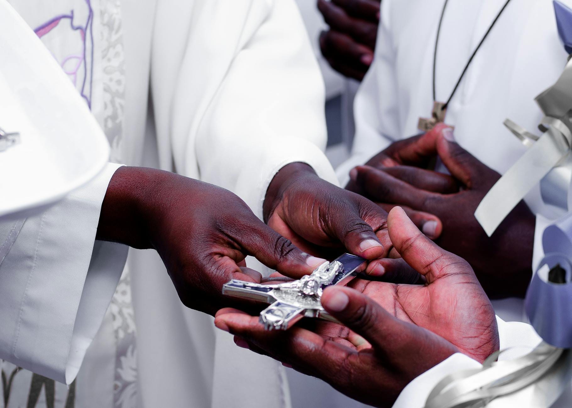 Kapłani przekazują sobie srebrny krzyż podczas ceremonii religijnej Kapłani przekazują sobie srebrny krzyż podczas ceremonii religijnej
