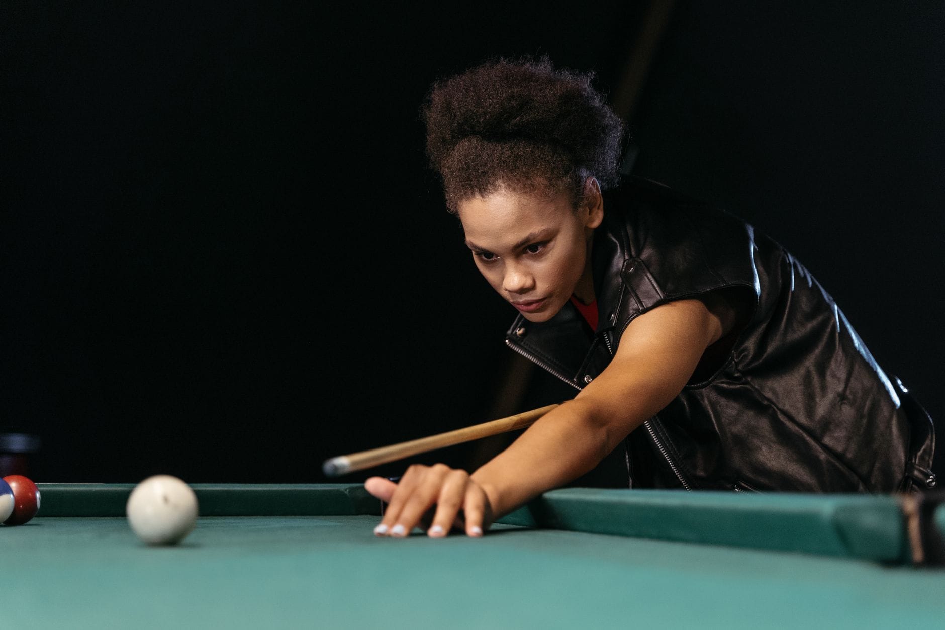 Z fokusowana zawodniczka celująca kijem w białą bilę na stole bilardowym Z fokusowana zawodniczka celująca kijem w białą bilę na stole bilardowym