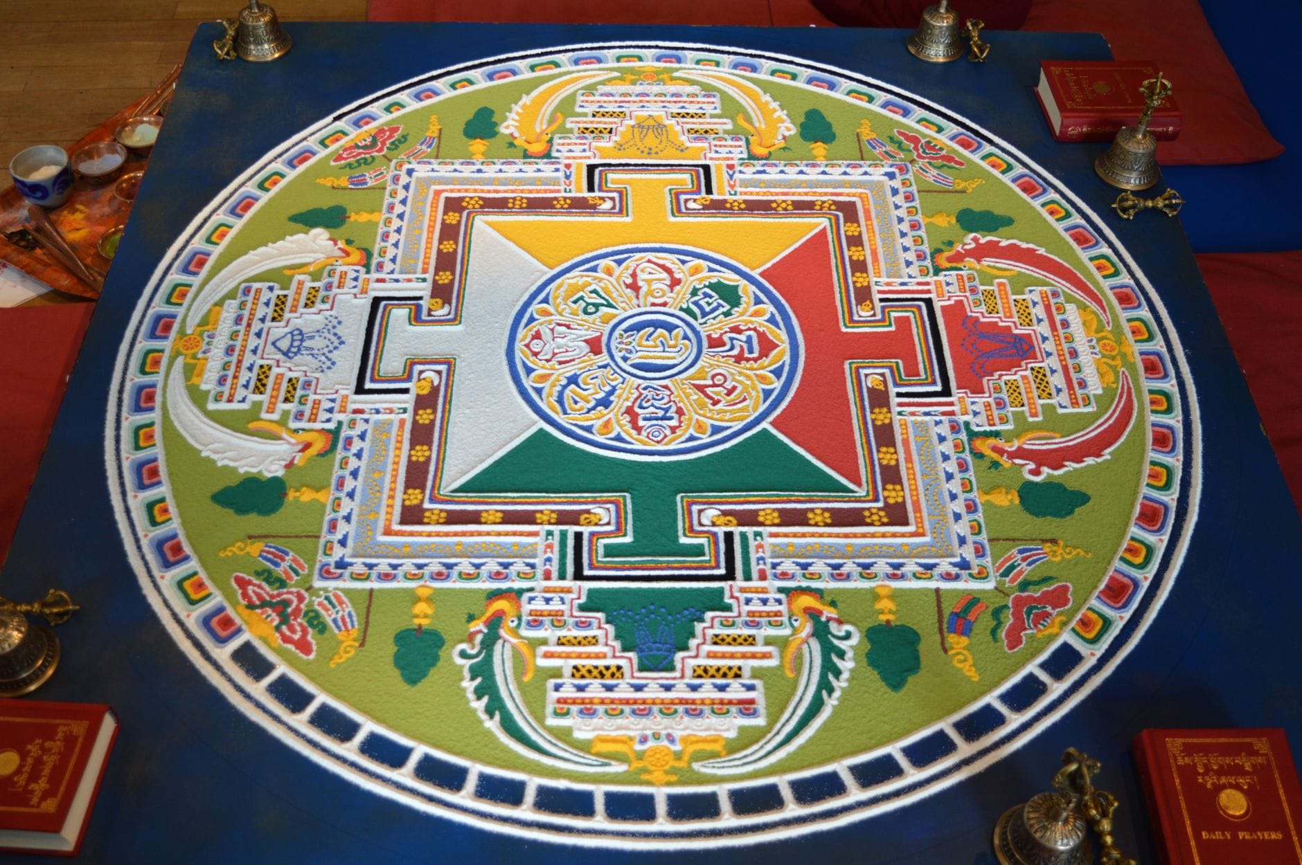 Kolorowa mandala z piasku o skomplikowanych wzorach w przestrzeni sakralnej
